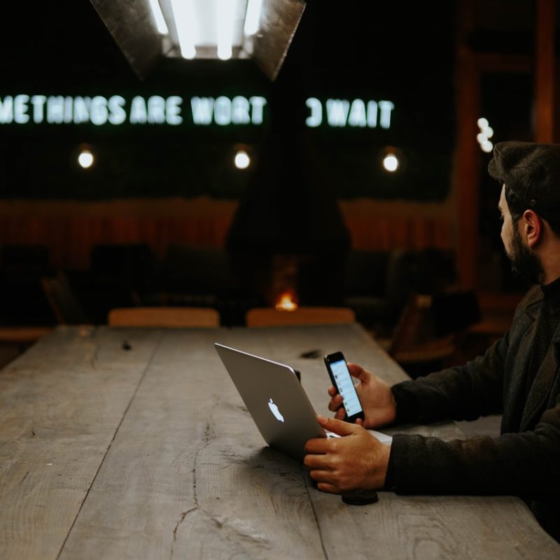 Man sat at a desk with phone and laptop