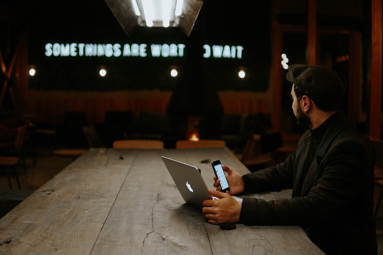 Man sat at a desk with phone and laptop